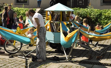 lecteurs sur des hamacs, avec une biblioth&egrave;que &agrave; roue centrale