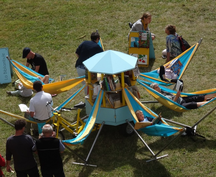 lecteurs sur des hamacs, avec une biblioth&egrave;que &agrave; roue centrale